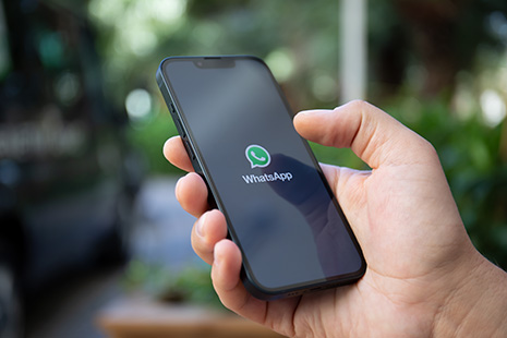Kontakt WhatsApp-Icon auf Smartphone von Handynutzer in der Hand