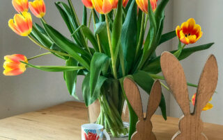Tulpenstrauß in einer Vase auf einem Tisch.