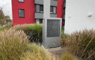 Eine Buderus-Wärmepumpe steht inmitten von Gebäuden.