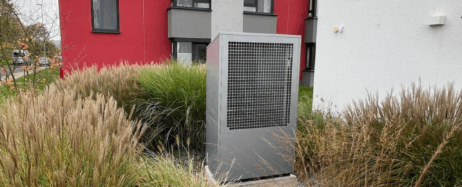 Eine Buderus-Wärmepumpe steht inmitten von Gebäuden.