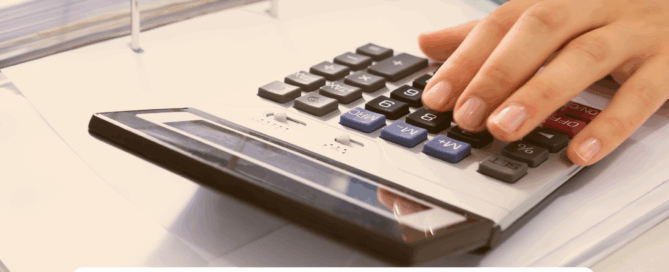 Buchhaltung bei der Faust Betriebs-GmbH - eine Person bedient einen Taschenrechner während sie gleichzeitig schreibt.